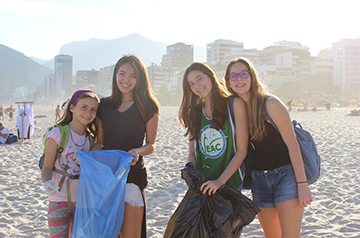 Alunas recolhendo lixo na praia