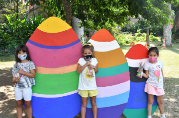 Crianças posando com ovos de páscoa gigante